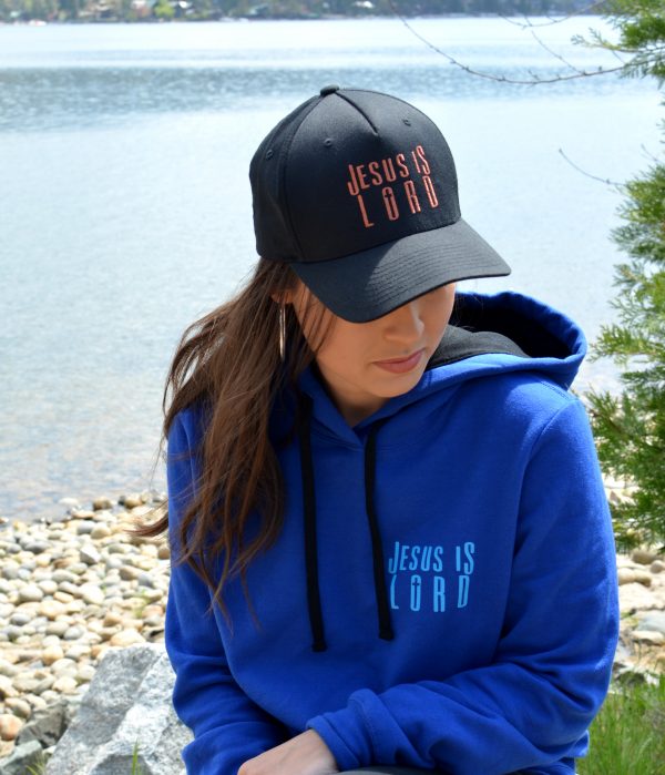 Christian woman at the lake wearing the Jesus is Lord Copper hat on a sunny day