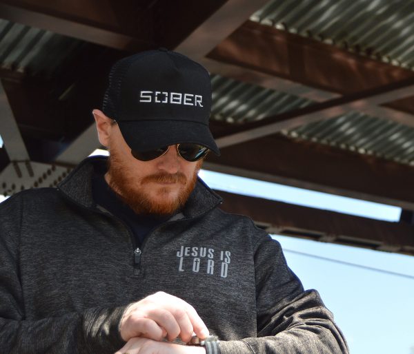 Christian man wearing posicharge Electric Black Sport Tek quarter zip pullover with Grey Jesus is Lord ink