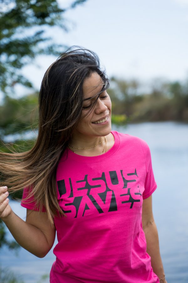 Smiling Christian woman near lake wearing Jesus Saves T-shirt